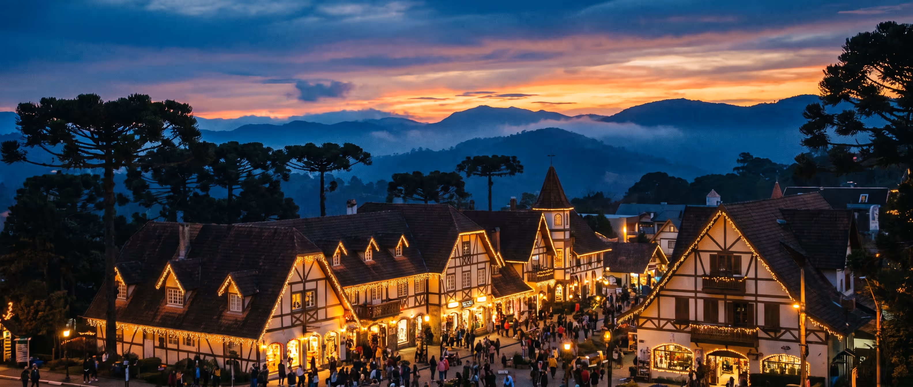 Rua de Gramado iluminada à noite, com decoração natalina e casas em estilo enxaimel